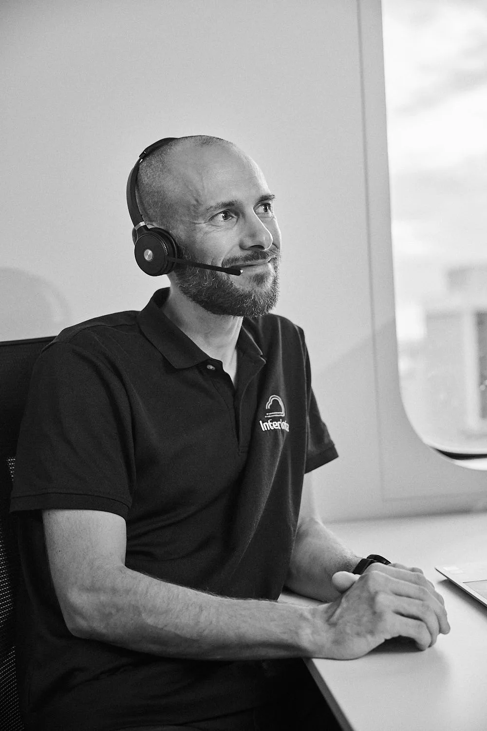 An InterIntra help desk engineer on a headset at their desk