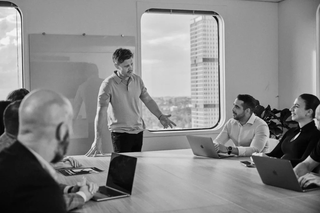 A group of people in a meeting around a board room table