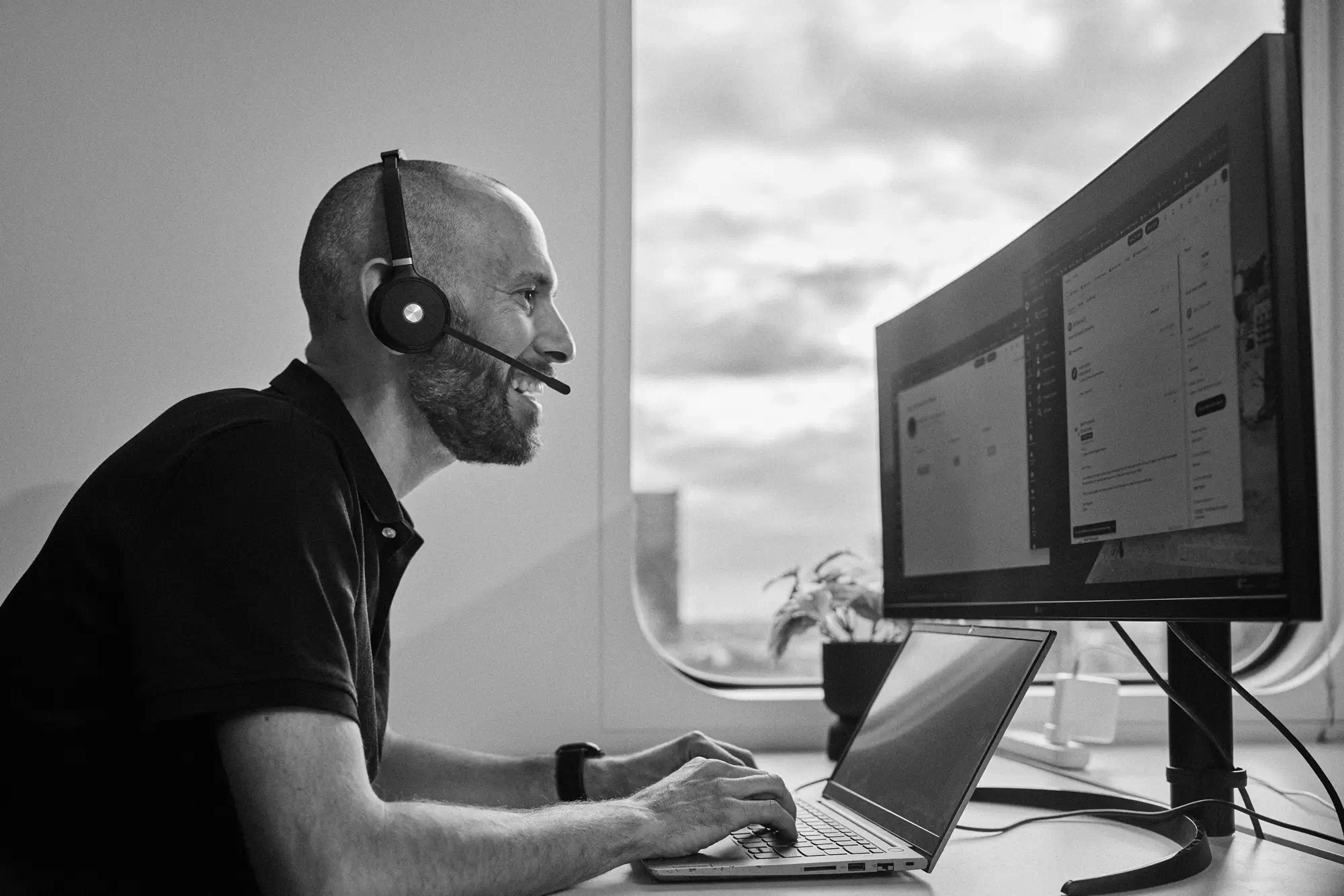 A man in a headset looking intently at a computer screen