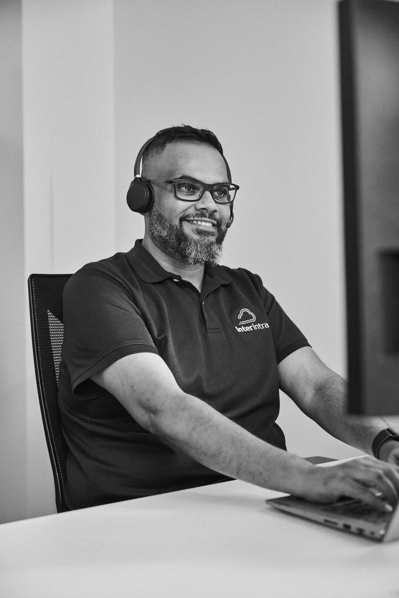 A man at a computer wearing headphones