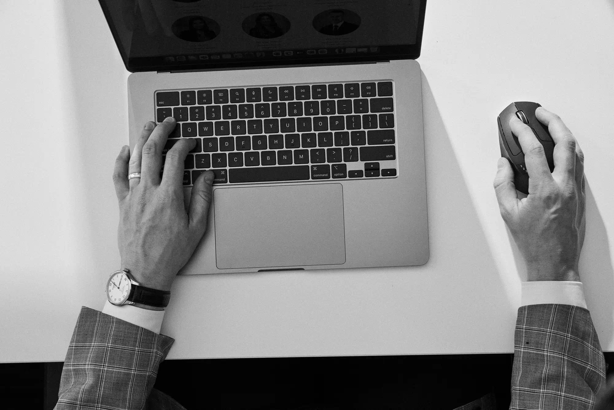 a computer on a desk with hands using it